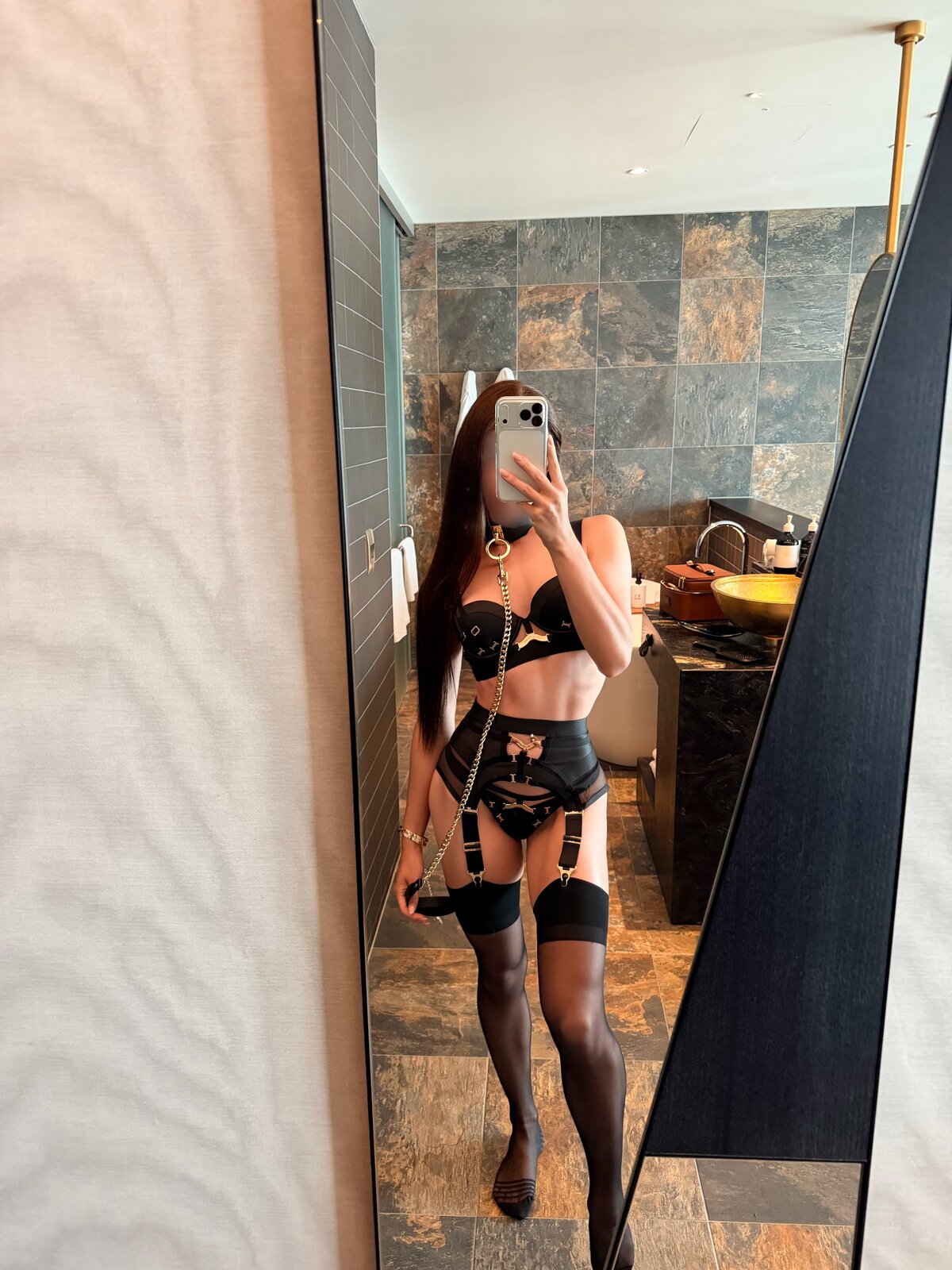 Irina, a full-length mirror selfie in black lace and stockings in a marble bathroom