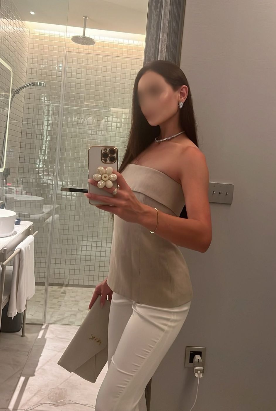 Irina, a marble-bathroom mirror selfie in a taupe strapless top and white trousers